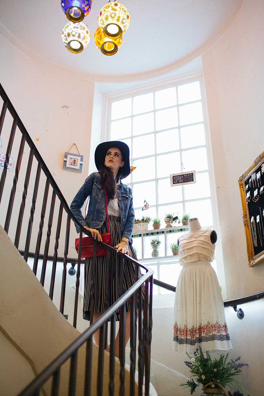 Woman in floppy hat standing on stairwell