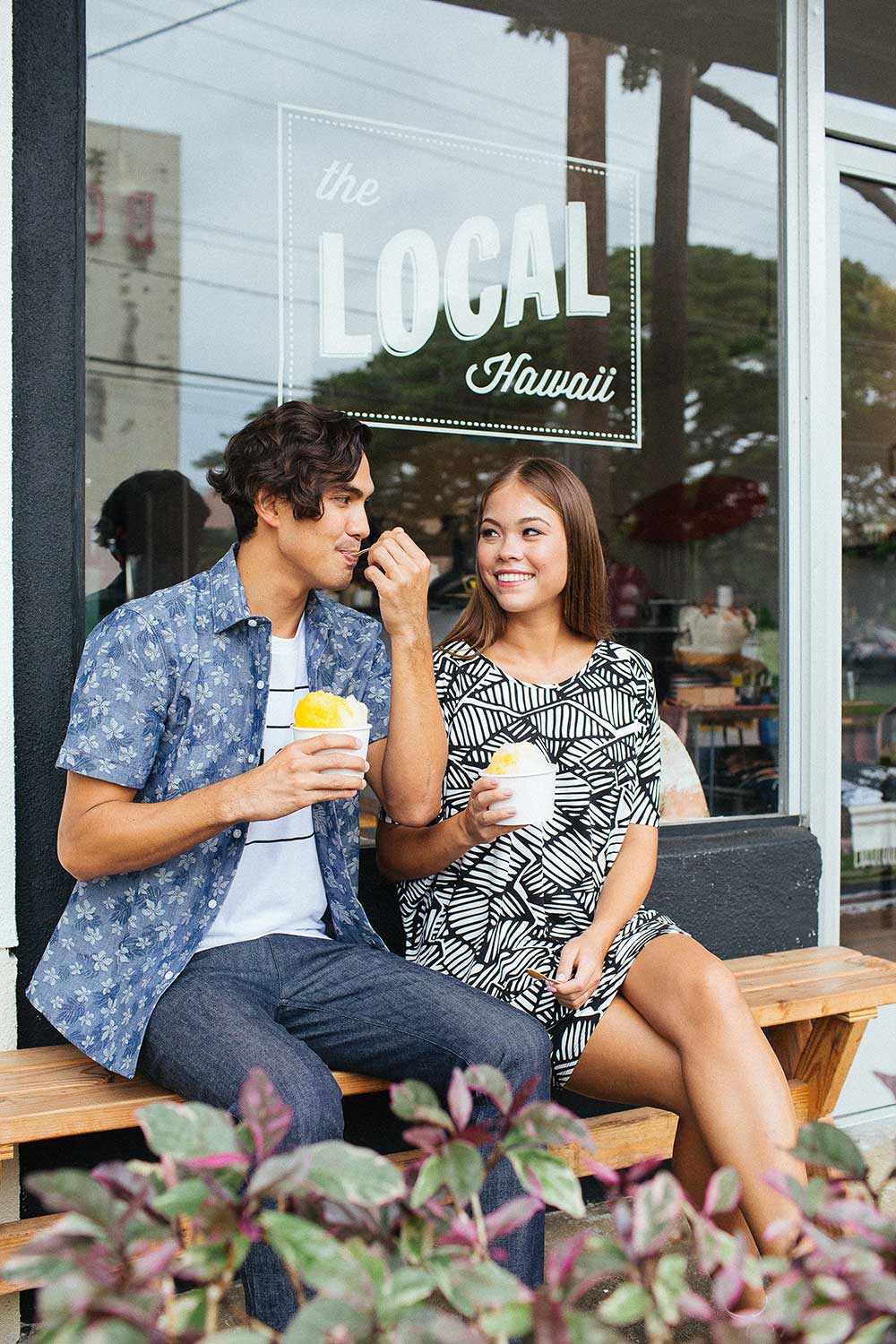 man and woman eating shave ice in front of Local Hawaii store