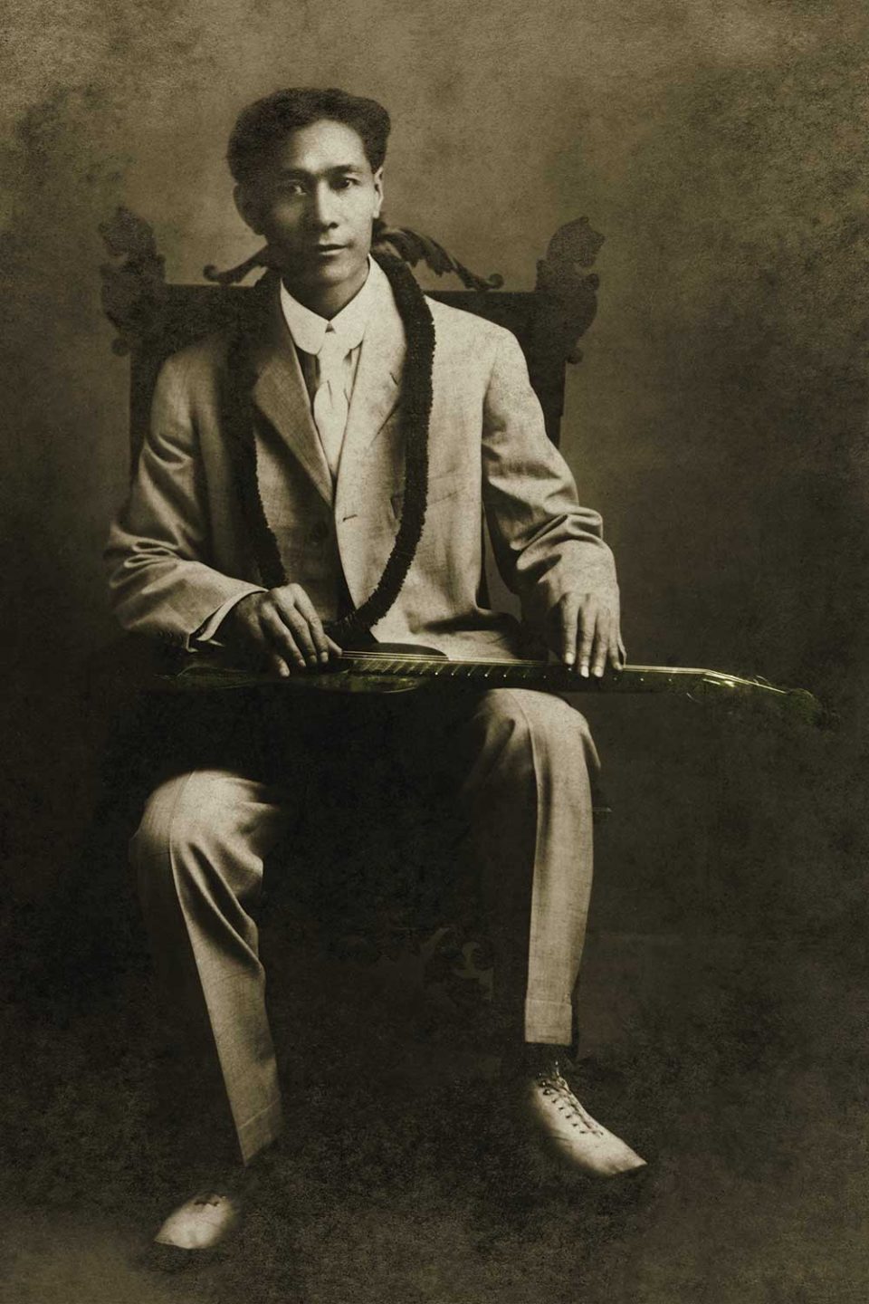 black and white photo of Joseph Kekuku with steel guitar on lap