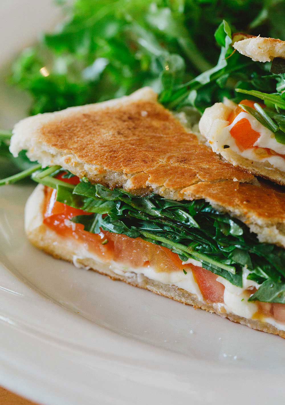 Manoa_4b White plate with half triangle sandwich and greens