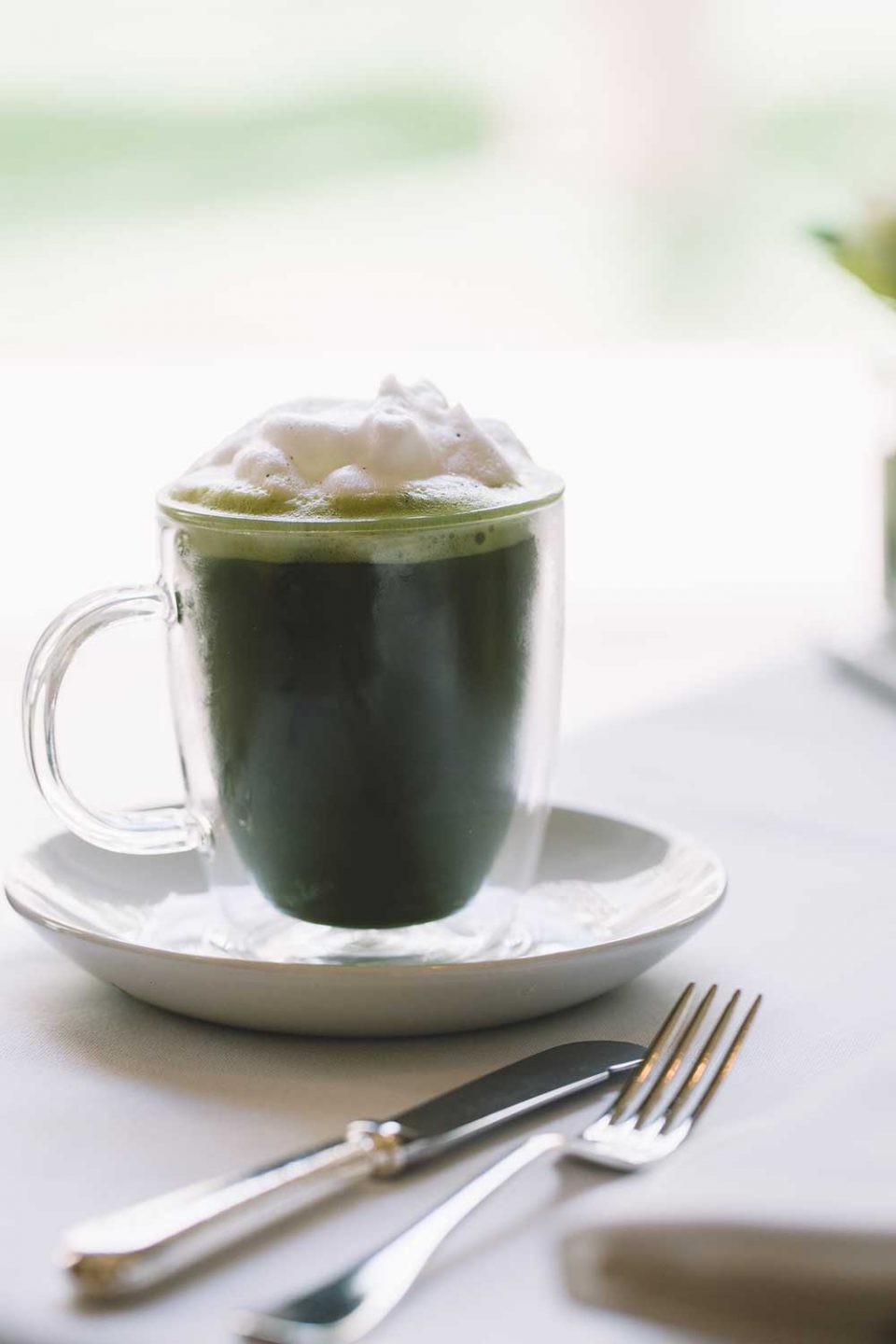 cup of Japanese tea with fresh whipped cream on table