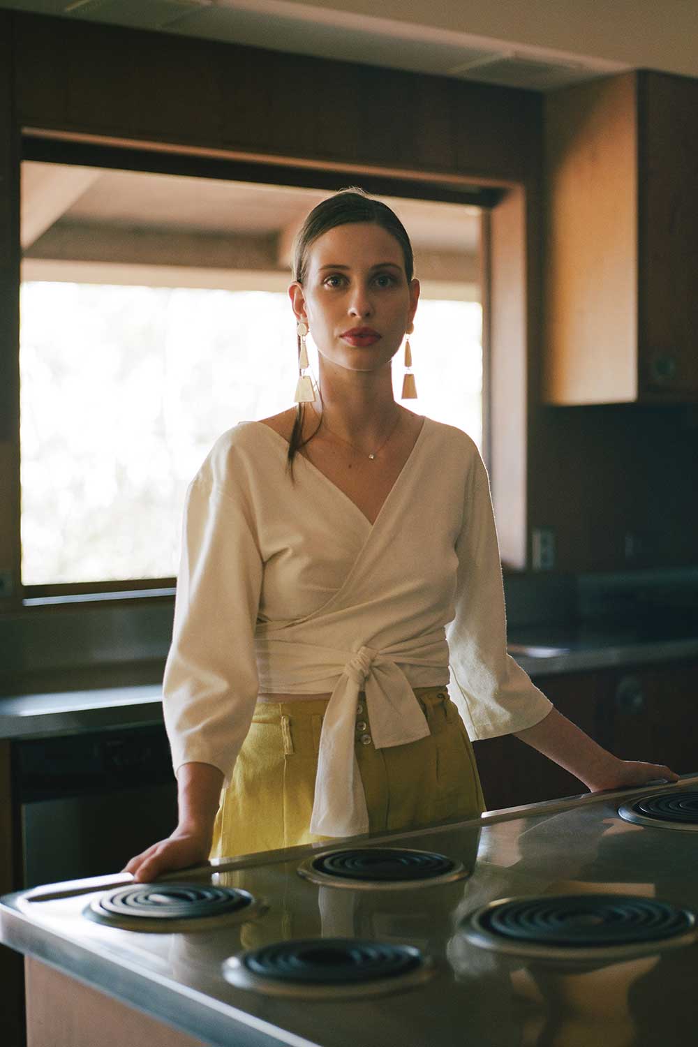 Woman in white top in kitchen