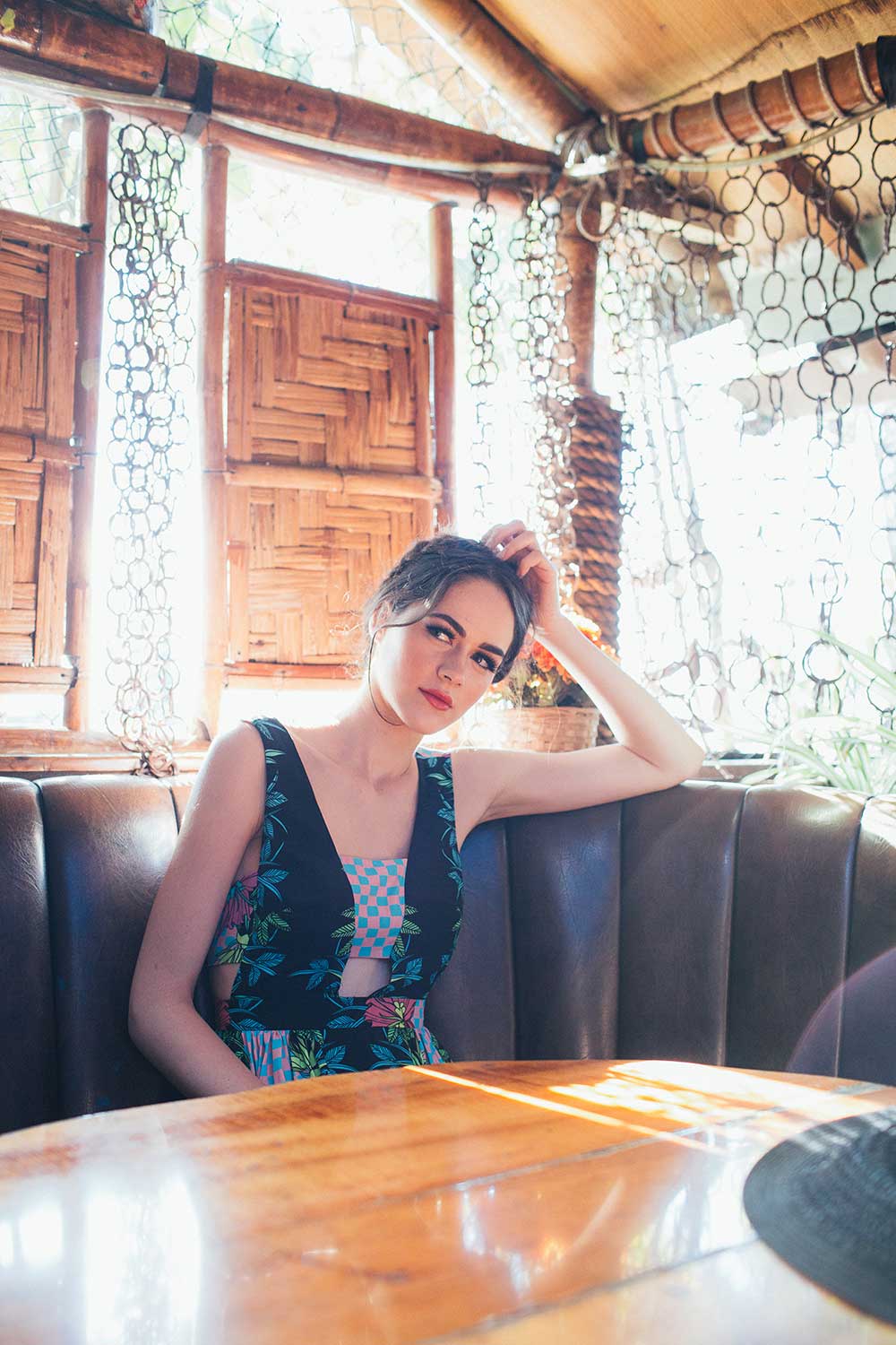 woman flowered dress sitting in restaurant booth